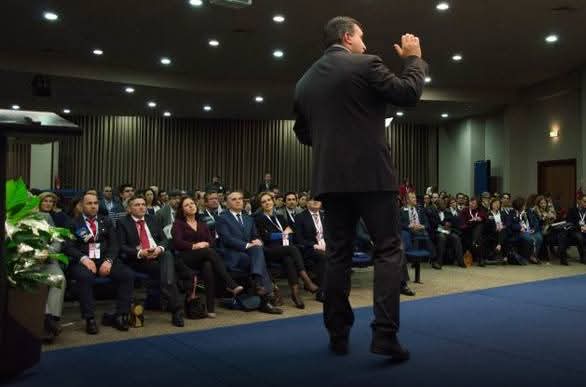 Nelson Basílio a falar num auditório, diante de uma plateia